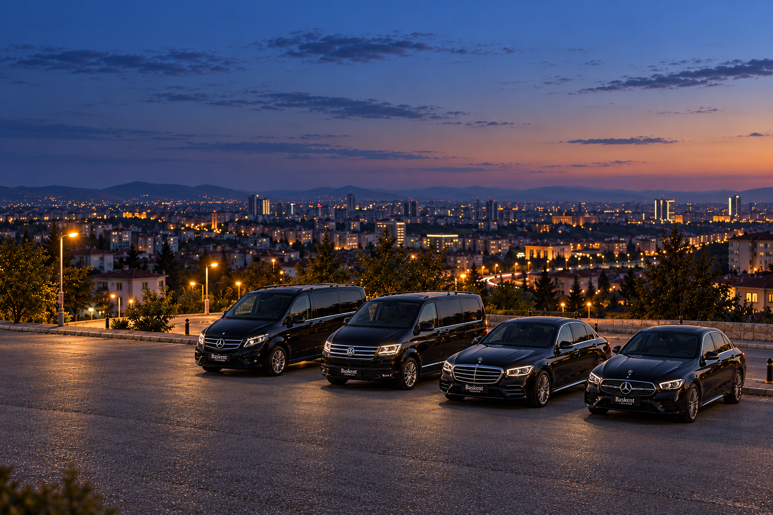 Akşam alacakaranlığında, puslu şehir ışıkları önünde yan yana park edilmiş dört transfer aracı